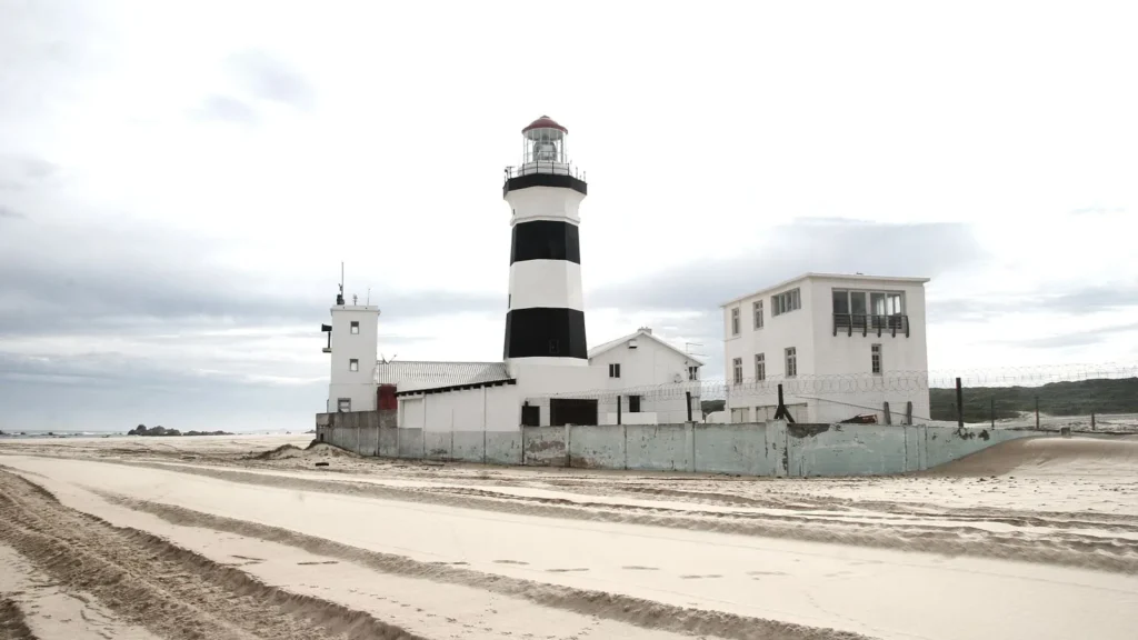 Gqeberha'da Cape Recife Deniz Feneri ve kumlu kıyı