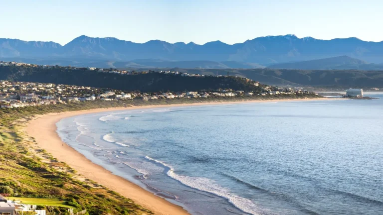 Plettenberg Bay kıyısı, dağlar ve sahil yerleşimi