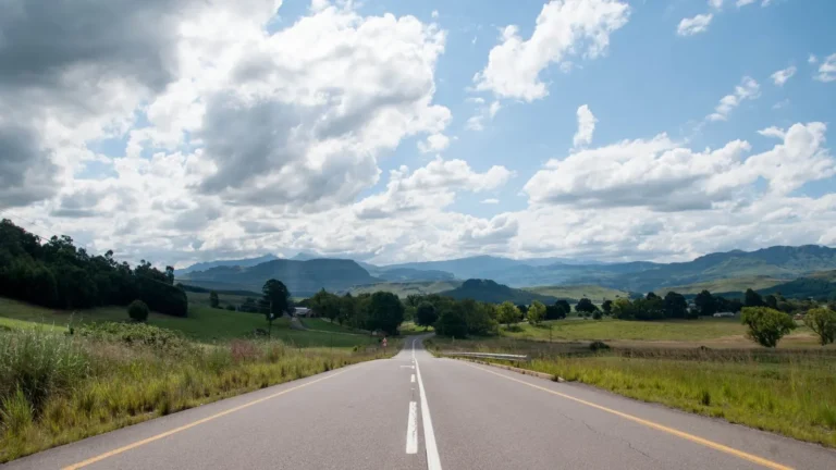 Güney Afrika kırsalında yeşil tepeler arasından uzanan açık yol